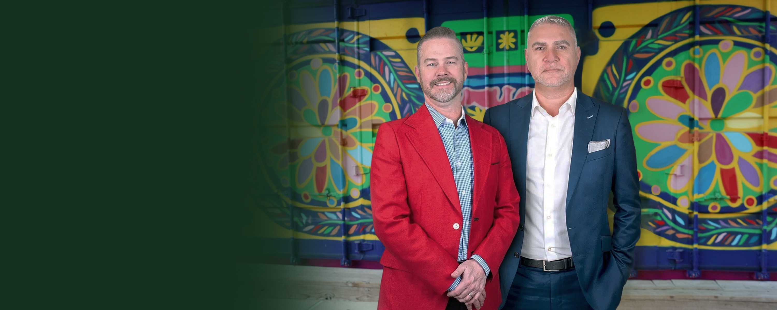 Dos abogados con los brazos cruzados frente a un mural colorido en un entorno urbano